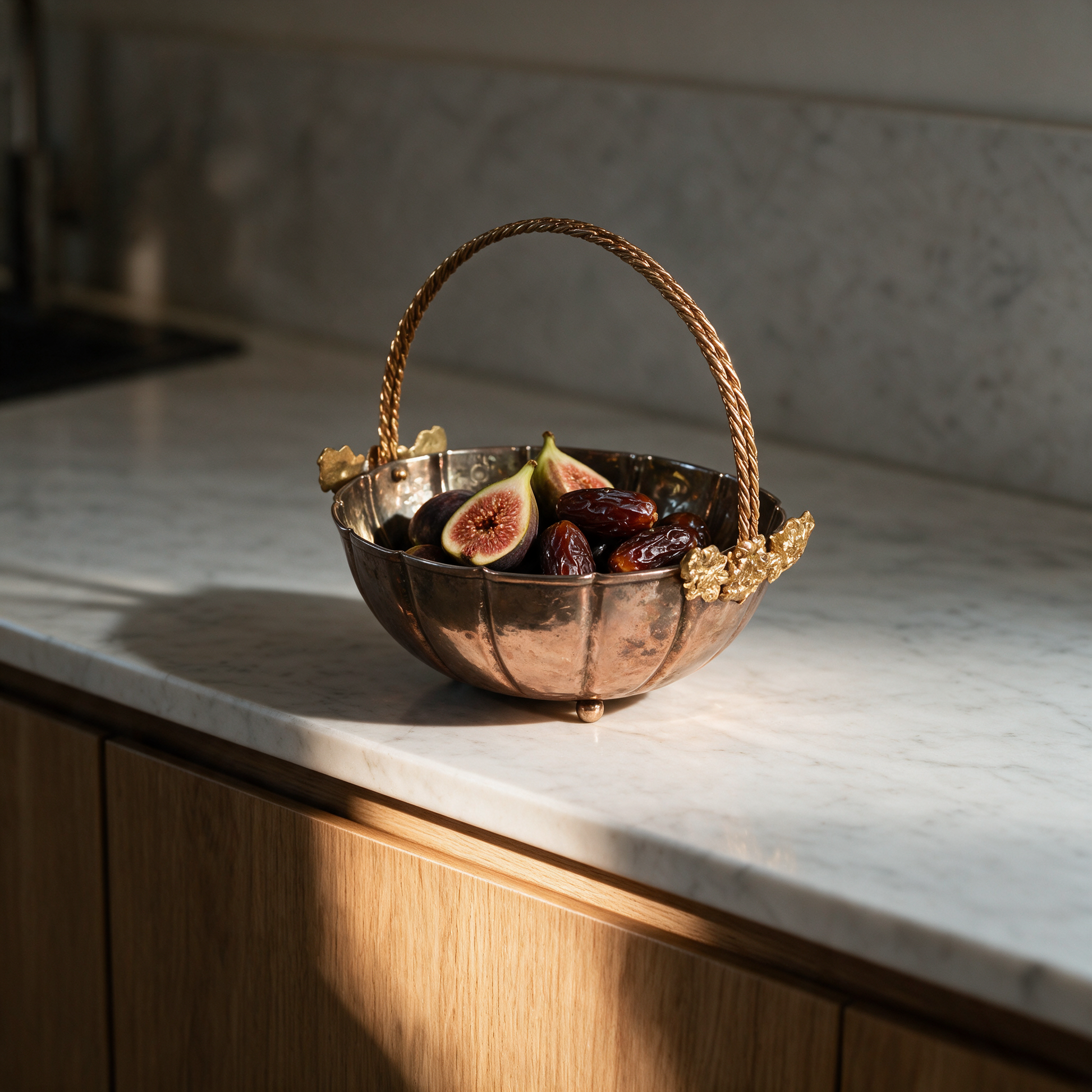 Golden Bloom copper basket with figs and dates on a marble kitchen counter in a modern Dubai villa