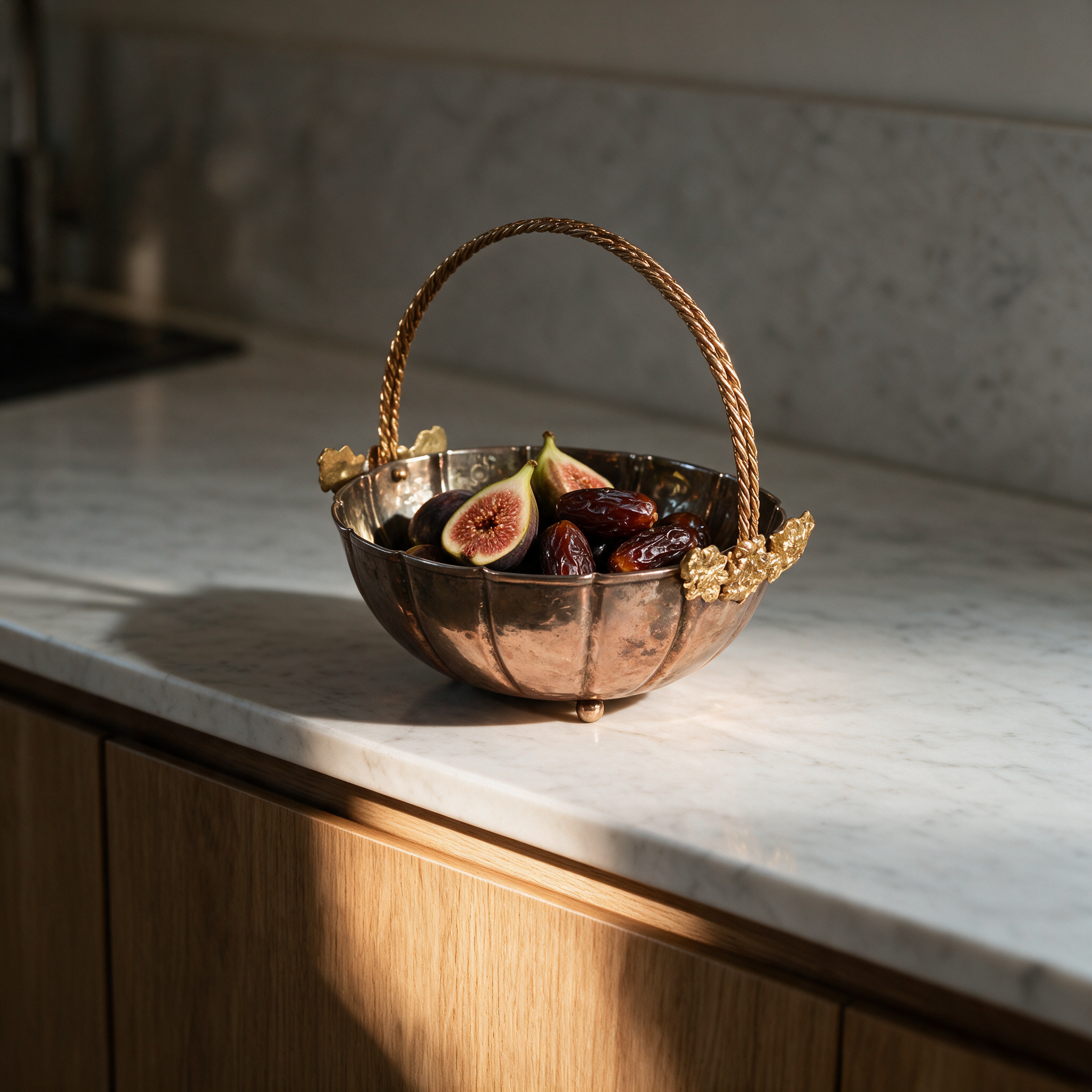 Golden Bloom copper basket with figs and dates on a marble kitchen counter in a modern Dubai villa